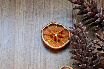 Dried orange slice and pine cones on a wooden table