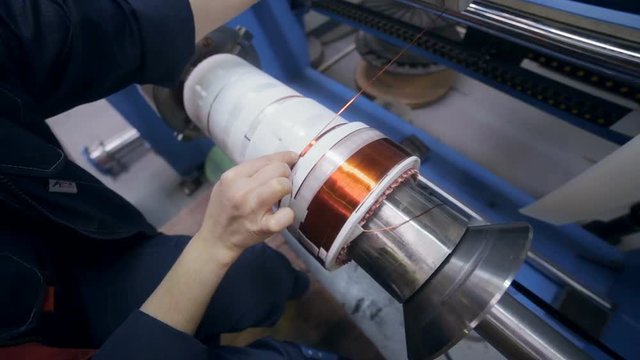 Transformer, engine production. Worker winding cooper wires on a high voltage transformer. Slider shoot. HD.