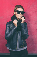 Obraz premium Portrait of young caucasian woman with sunglasses looking at camera and standing against of purple background
