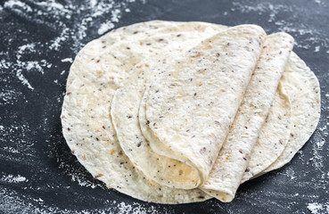 Stack of tortillas on a black surface