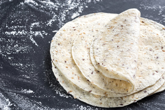 Stack of tortillas on a black surface