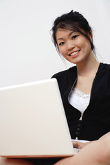 Young woman with laptop, looking at camera