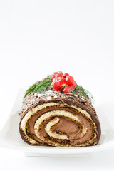 Chocolate yule log cake with red currant isolated on white background
