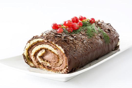 Chocolate yule log cake with red currant isolated on white background
