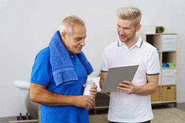 therapeut zeigt einem patienten etwas am tablet