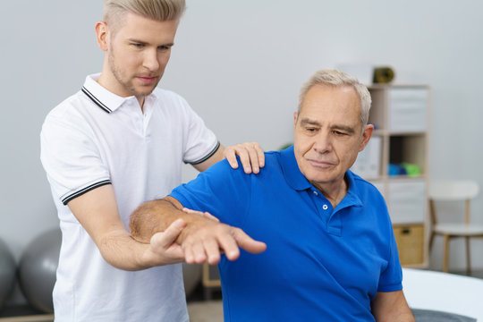 physiotherapeut untersucht die schulter eines älteren patienten