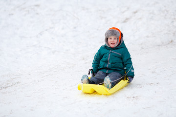 Fototapeta na wymiar little boy sledding