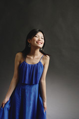 Obraz premium Woman in blue dress, eyes closed, smiling