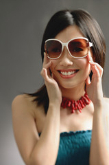 Naklejka premium Woman wearing large sunglasses, smiling at camera