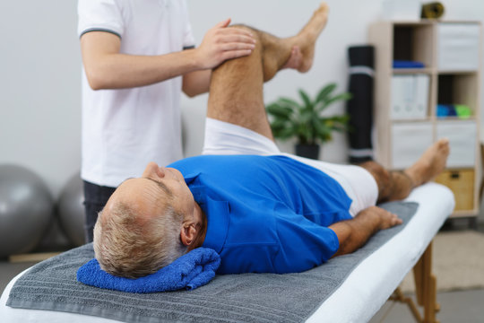 senior lässt sein knie beim therapeuten behandeln