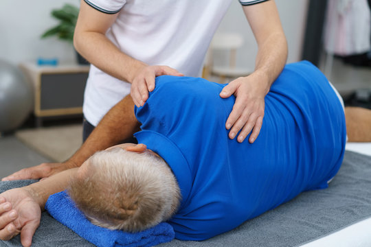 physiotherapeut behandelt einen älteren mann an der schulter