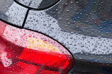 Regentropfen auf einem Auto mit Rücklicht