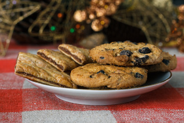 Homemade cookies in a plate on the feast of the new year, christmas. Tasty cookies on a table with a Christmas tree in the background.