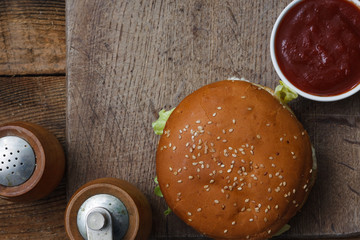 The Burger and the fresh ingredients on the old Board. On a black chalkboard. Top view.