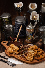 A large plate of appetizers to beer. Meat, squid, vegetables, po