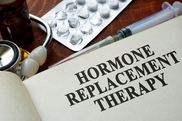 Book with words hormone replacement therapy on a table. - obrazy, fototapety, plakaty