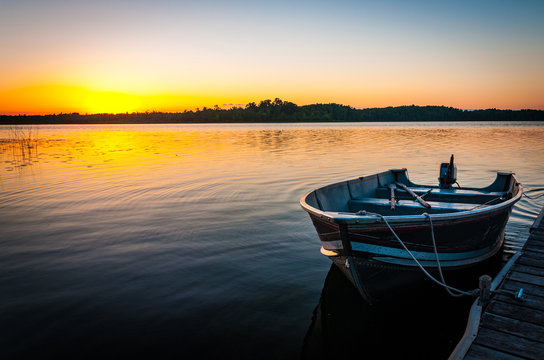 Fishing Boat On Tranquil Lake At Sunset In Minnesota