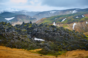 Fototapeta na wymiar Valley National Park Landmannalaugar. On the gentle slopes of the mountains are snow fields and glaciers. Magnificent Iceland in the August