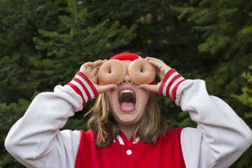 A teenage girl being silly holding two donuts over her eyes in Sagle, Idaho.