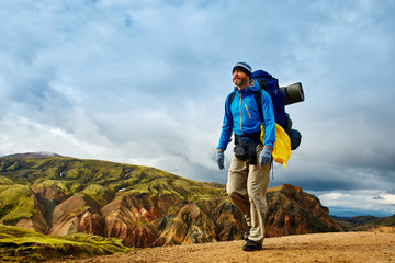 Naklejka premium man hiker on the trail in the Islandic mountains. Trek in National Park Landmannalaugar, Iceland