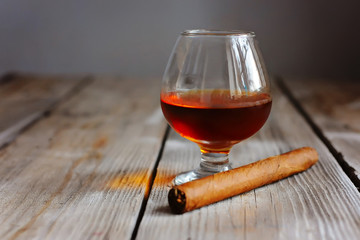 whiskey with smoking cigar on wooden table
