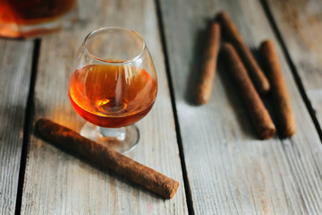 whiskey with smoking cigar on wooden table