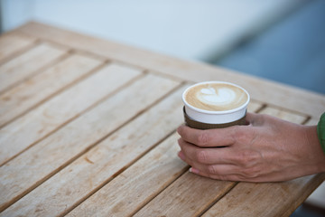 Female hand holding a paper coffee cup