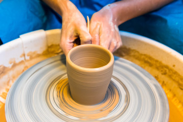 womens hands of a potter creating an earthen jar