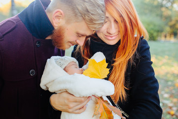 young family and newborn son in autumn park