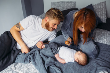 Young parents giving of attention to their baby.