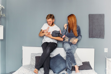 Young family with a baby by the wall