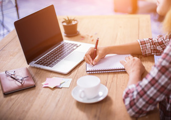 Business Woman Writing with pen in notepad on workplace.