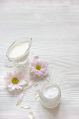 cream and spa on wooden background with flowers
