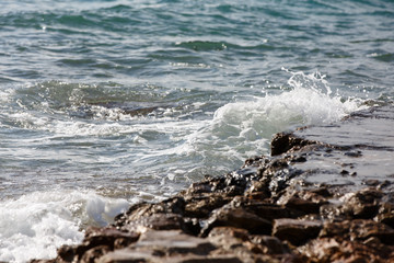 The waves break on the rocks and the splashes of water. Evening.