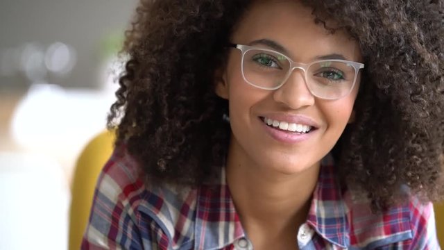 Mixed-race girl with eyeglasses reading book at home