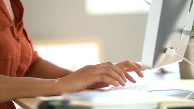 Closeup of woman's hands typing on keyboard