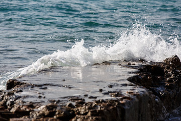 The waves break on the rocks and the splashes of water. Evening.