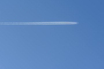 large passenger plane and contrail on blue sky
