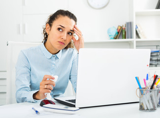 Unhappy businesswoman working at laptop in office