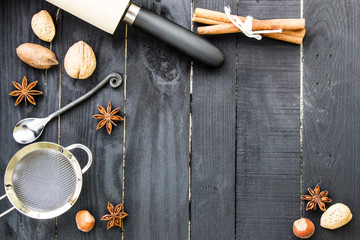 Christmas and New year menu. Baking ingredients and tools on the black rustic wooden background. Top view. 