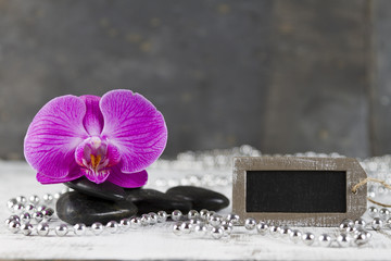 wellbeing concept with hot stones and pink orchid