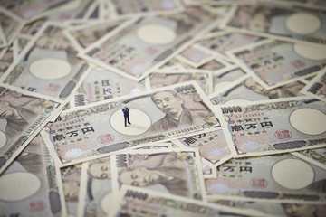 Miniature man with Japanese yen bills 