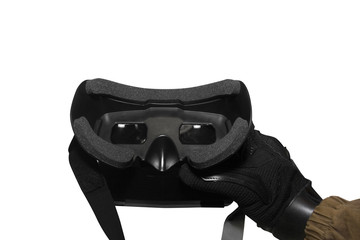 Isolated first person view soldier arm in black battle gloves & tactical jacket holding vr glasses.