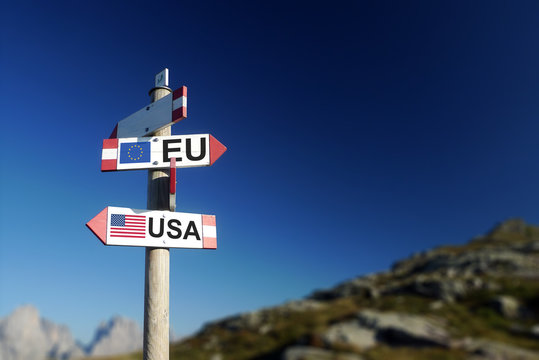 USA and UE flags on mountain signpost. At the top of the agenda concept.