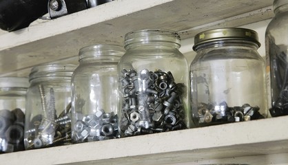 Various vintage old jars with metal bolts, nuts and screws
