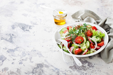 Fresh salad with cherry tomatoes, cucumbers, radishes, dill and olive oil, selective focus