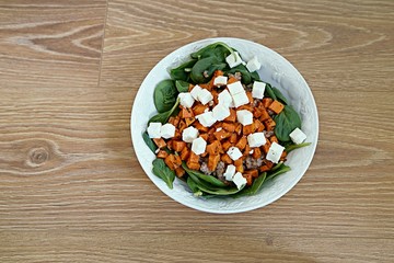 Healthy lunch with feta and spinach on wooden background