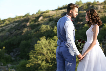 Bride and groom standing over beautiful landscape