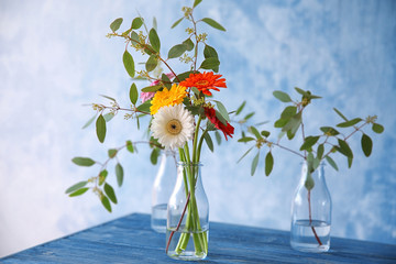 Flowers in vase on color background