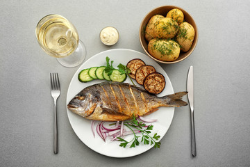 Tasty fish with vegetables on kitchen table